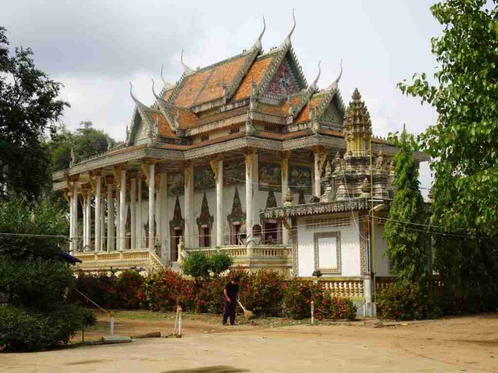 man sweeping at Ek Phnom Temple in Battambang Cambodia