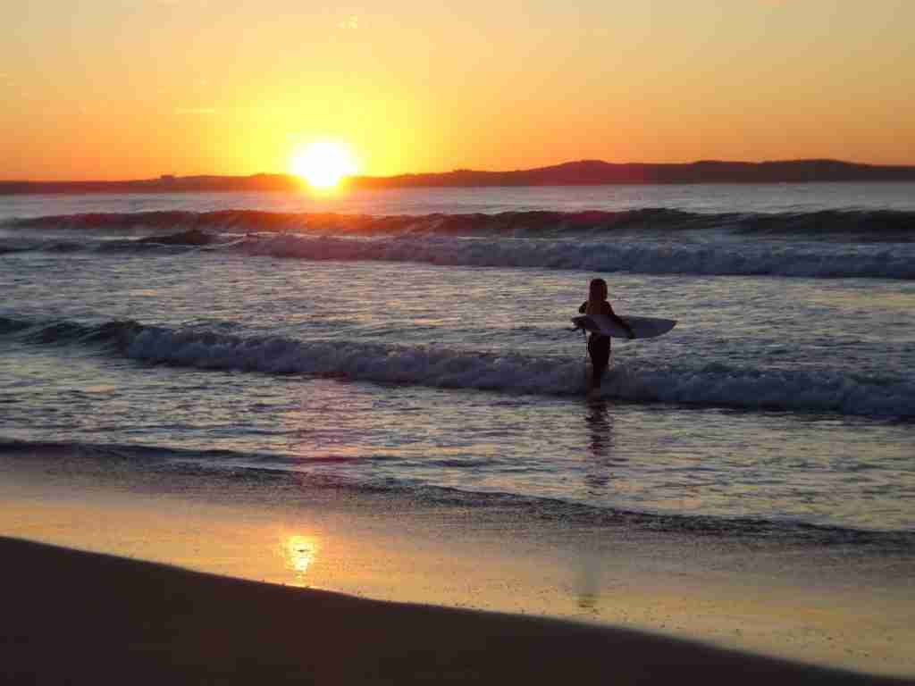 a surfer enjoying a Sydney sunrise at Cronulla Beach