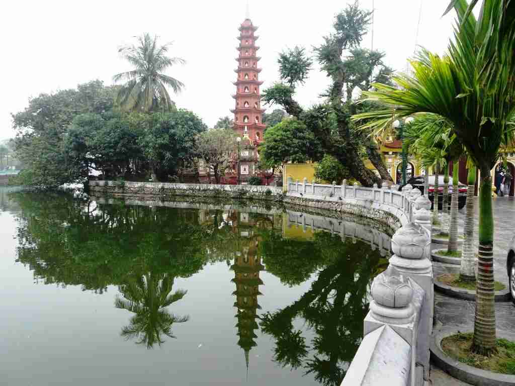 the spire of Tran Quoc Pagoda in Hanoi reflected in the water