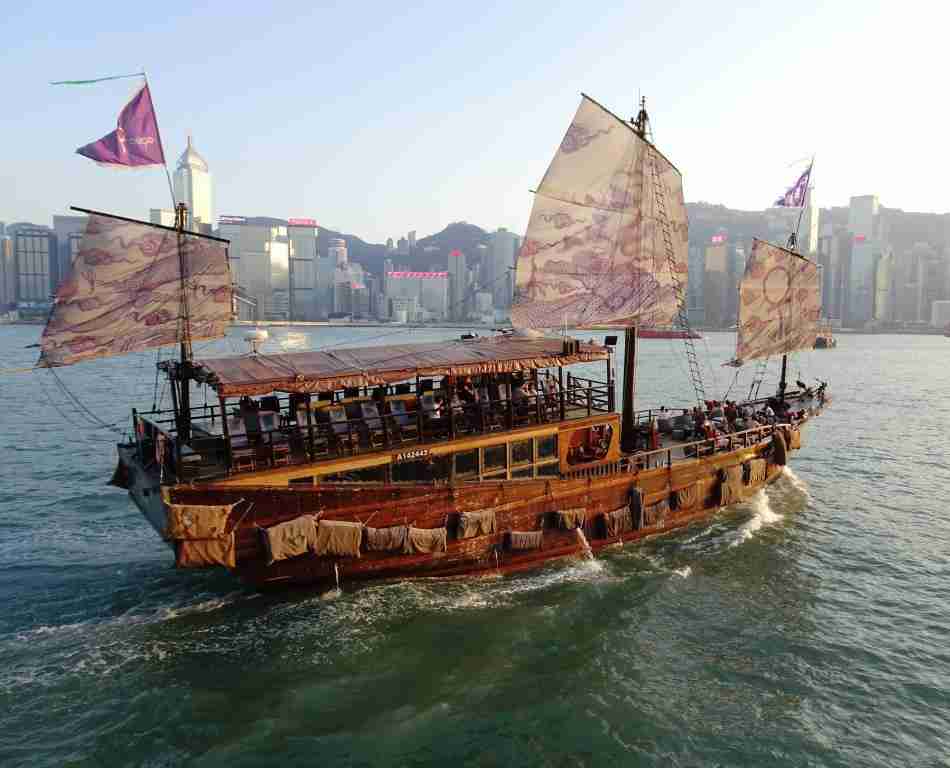 Traditional Chinese Junk boat with purple sails on Victoria Harbour, Hong Kong