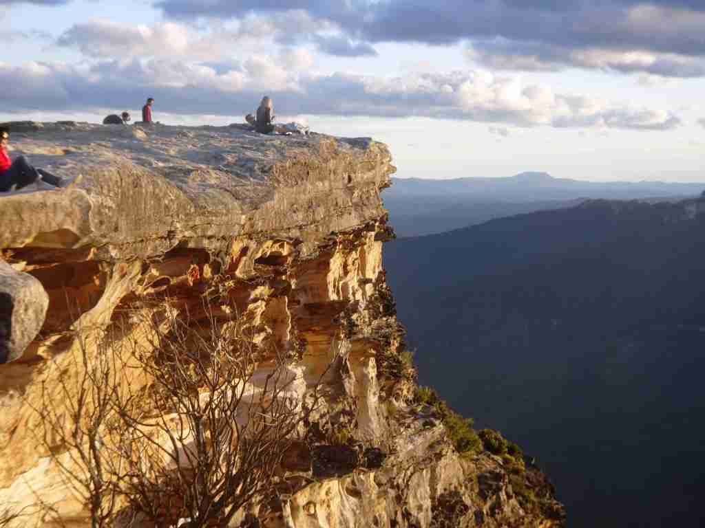 people sitting and watching the sunset on Lincoln Rock at Wentworth Falls in The Blue Mountains in Australia