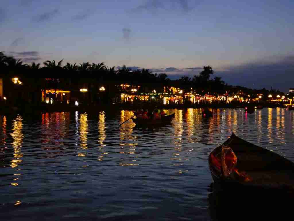 Boats on the river with lights reflected on the water at night in Hoi An Vietnam