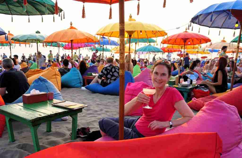 sipping cocktails on a colourful beanbags on the beach at sunset in Seminyak, Bali