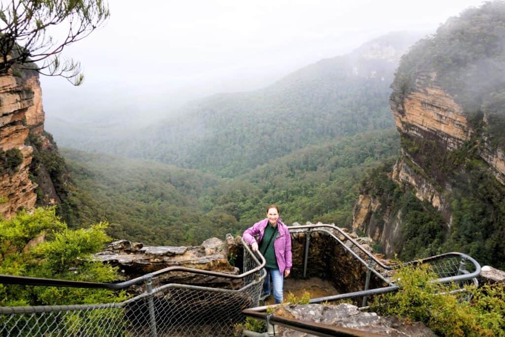 woman standing at a lookout point in misty weather