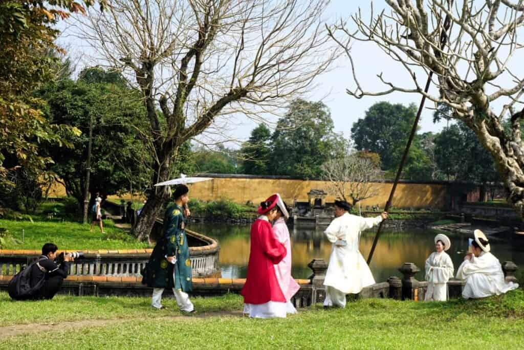 Young people taking photos in traditional dress at the Imperial citadel in Hue