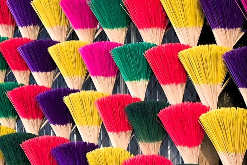 a wall with a dislpay of brightly coloured insence sticks
