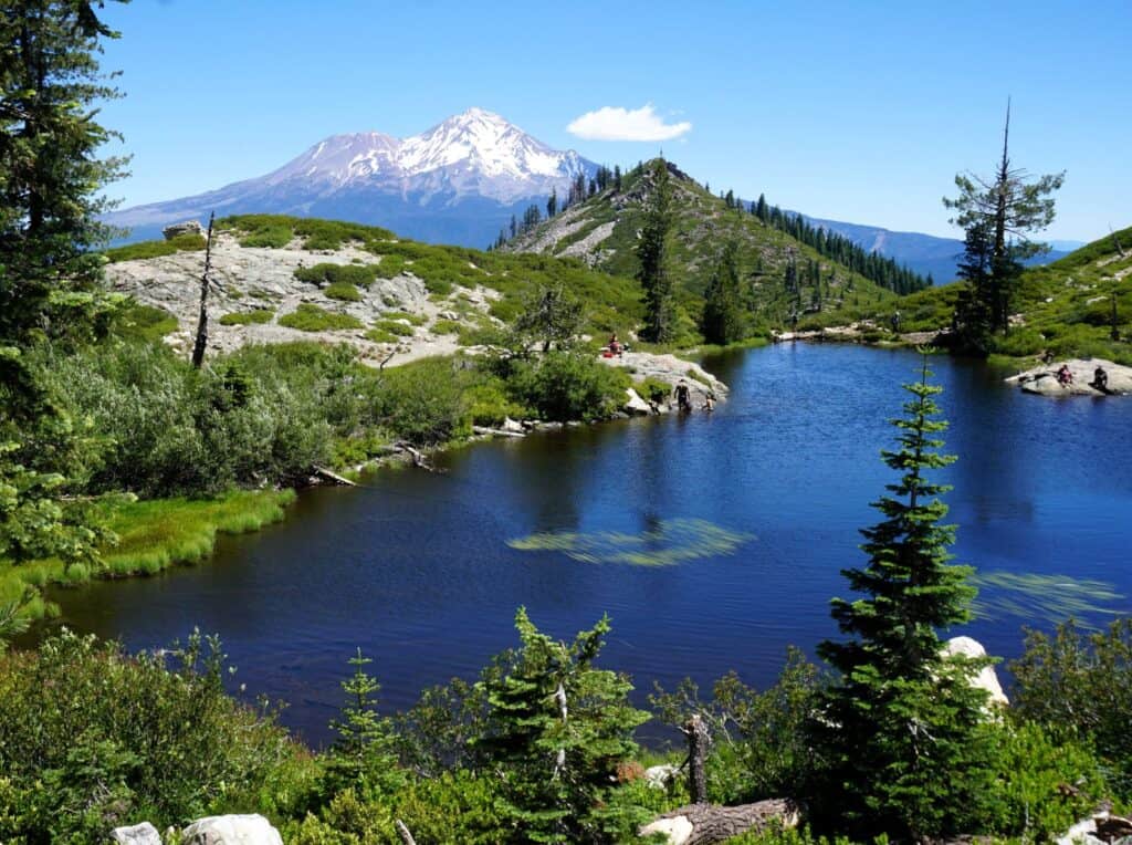 snowcapped Mount Shasta rising behind blue Little Heart lake