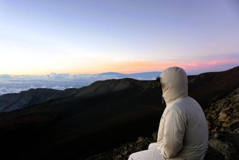 solo figure in a hoodie watching the Haleakala sunrise on Haleakala Maui