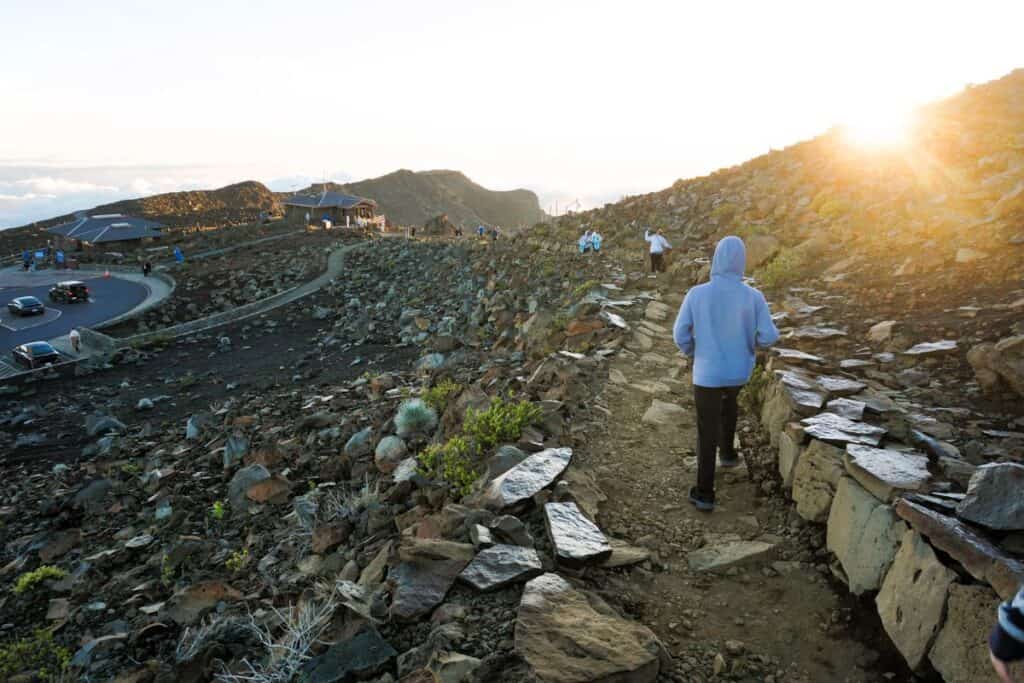 walking along a rocky mountain path just after sunrise on Haleakala Maui