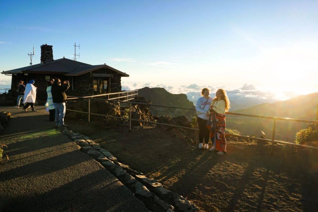 people taking photos near the crater after sunrise at the summit of Haleakala Maui