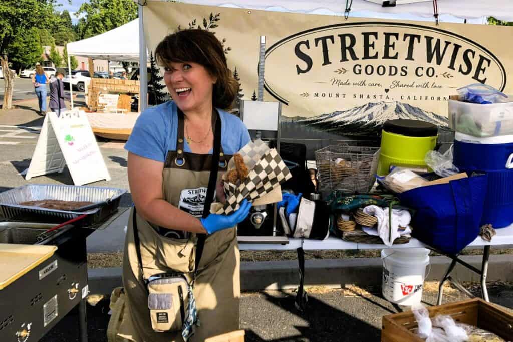 smiling woman selling churros at the Mount Shasta farmers market